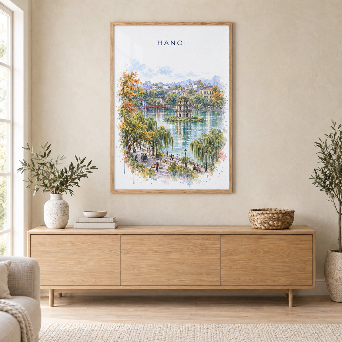 Hanoi watercolor print in an oak frame above a light wood sideboard in a Scandinavian living room