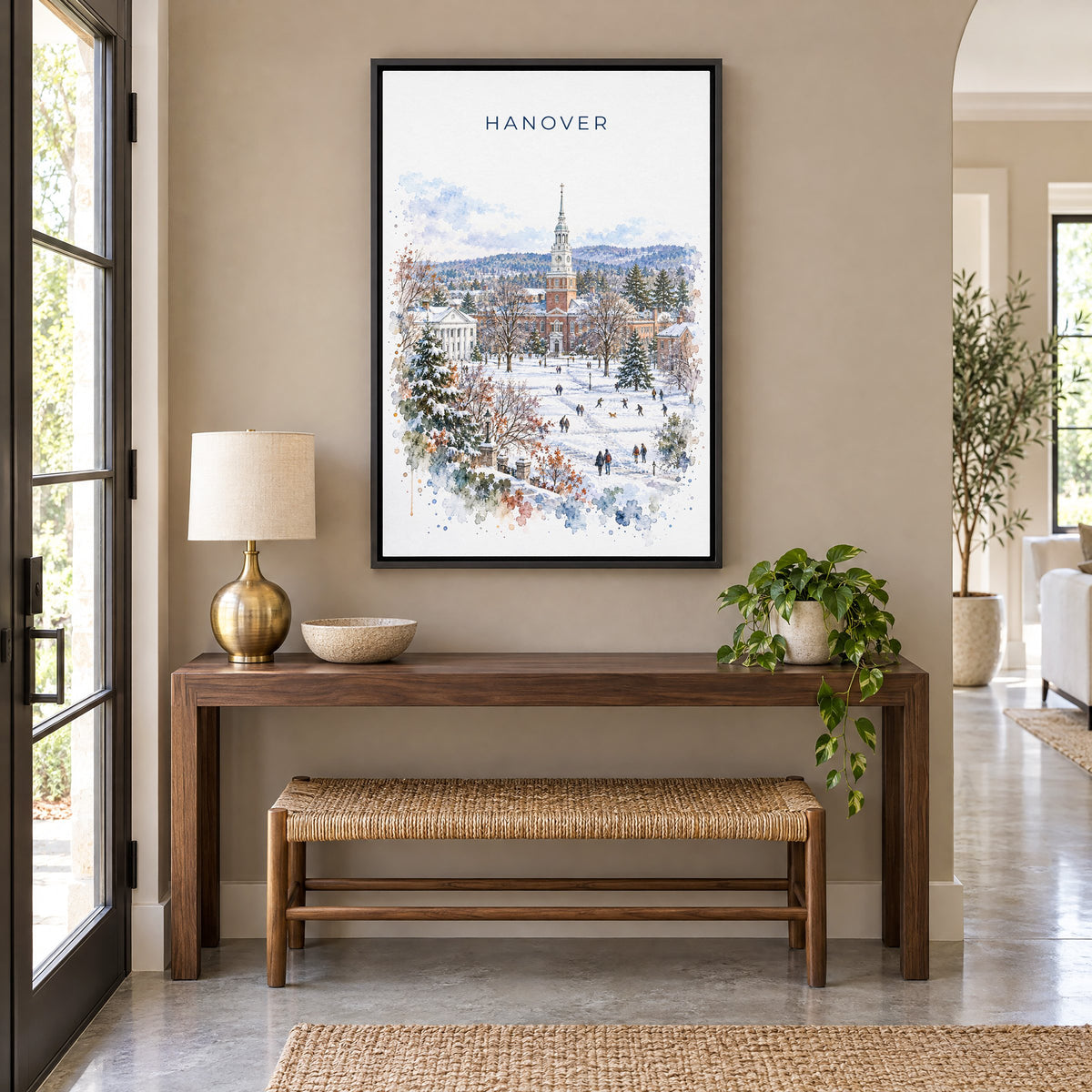 Hanover, New Hampshire watercolor print as a black floater canvas above a walnut console and woven bench in an entryway