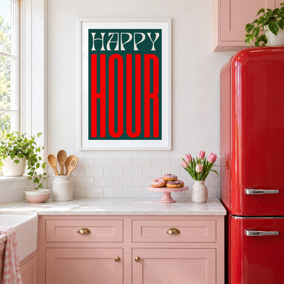 Happy Hour red and teal type print in a white frame in a pink kitchen beside a red retro fridge