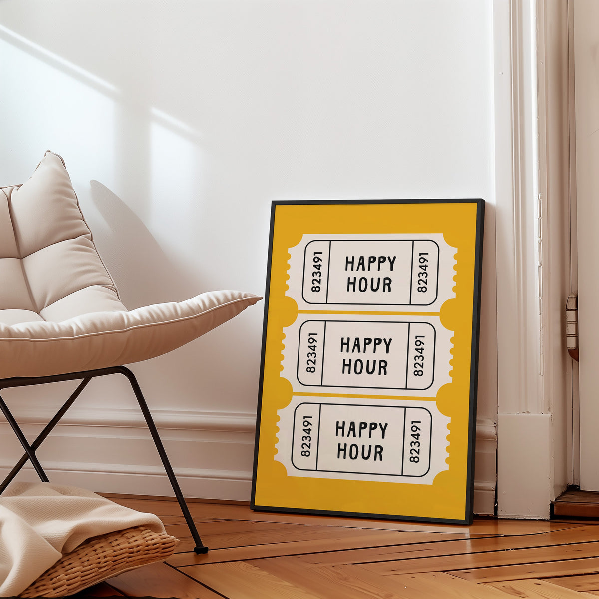 Happy Hour yellow tickets print in a slim black frame leaning on a herringbone floor beside a cream armchair