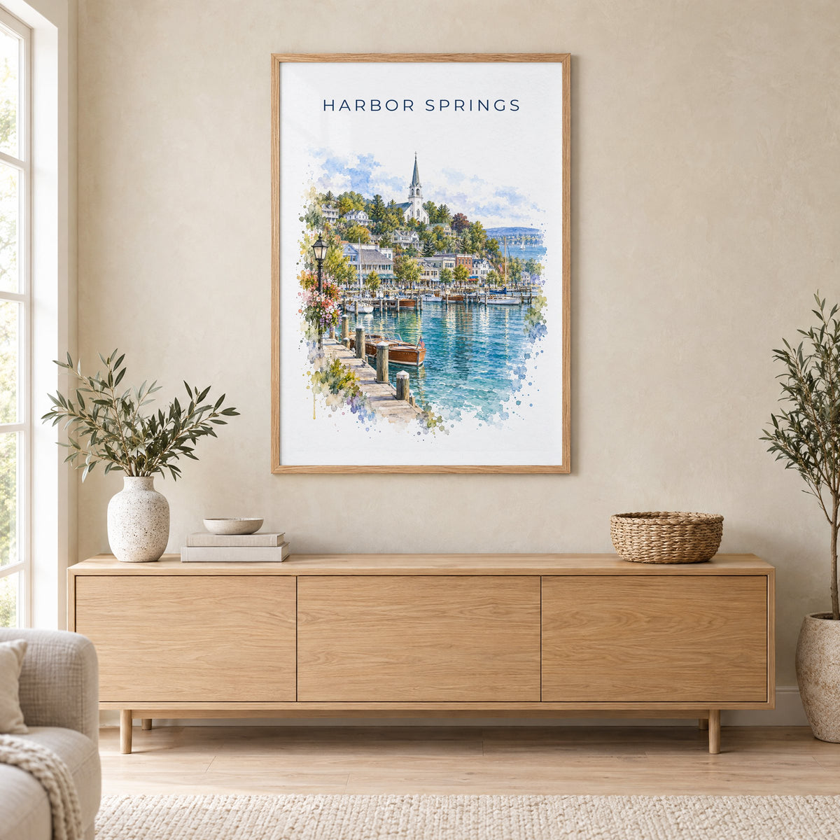 Harbor Springs, Michigan watercolor print in an oak frame above a light wood sideboard in a Scandinavian living room