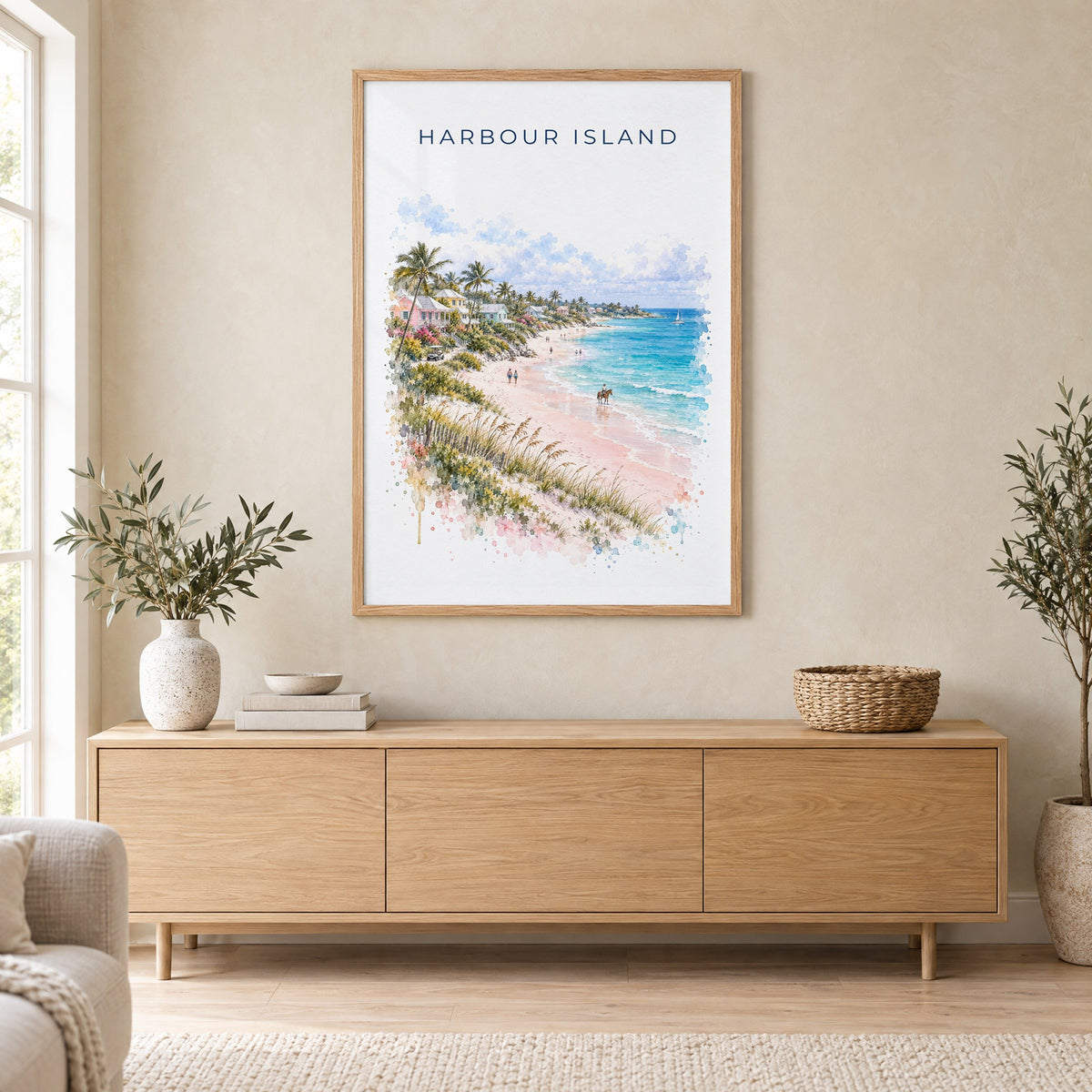 Harbour Island watercolor print in an oak frame above a light wood sideboard in a Scandinavian living room