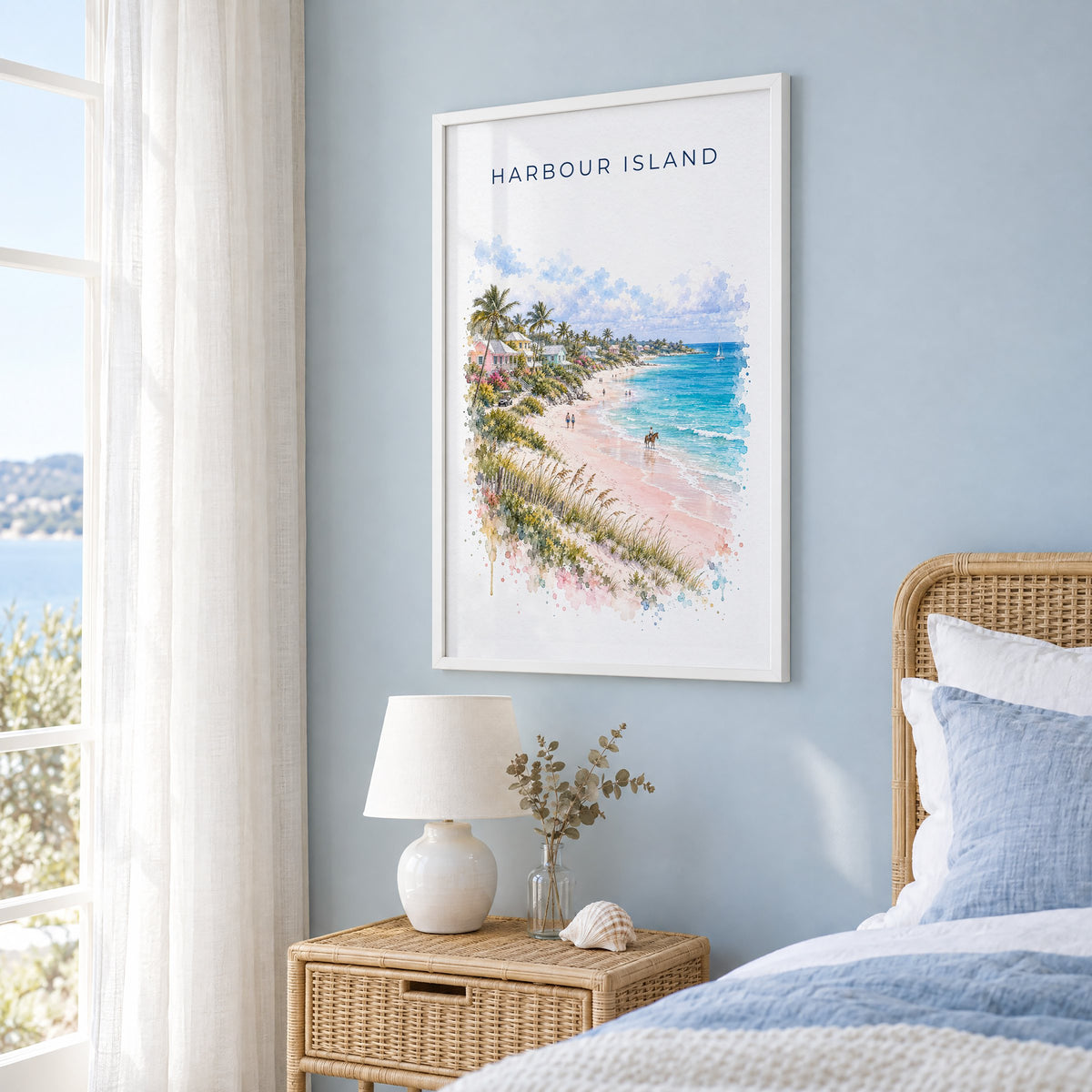Harbour Island watercolor print in a white frame on a pale blue wall beside a rattan bed in a coastal bedroom