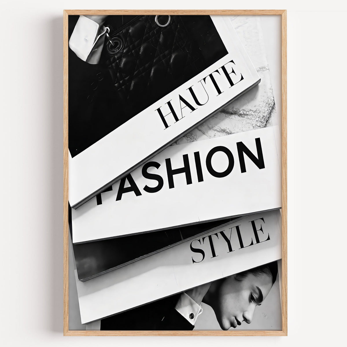 Stacked HAUTE FASHION STYLE books flat lay print in a light oak frame on a plain white wall