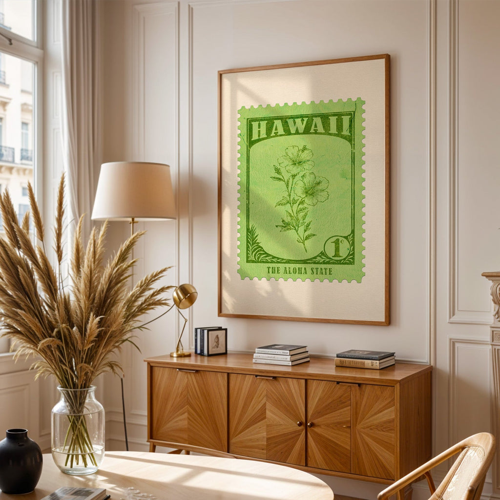 Hawaii stamp print framed above a wooden sideboard, pampas grass in a glass vase and a floor lamp