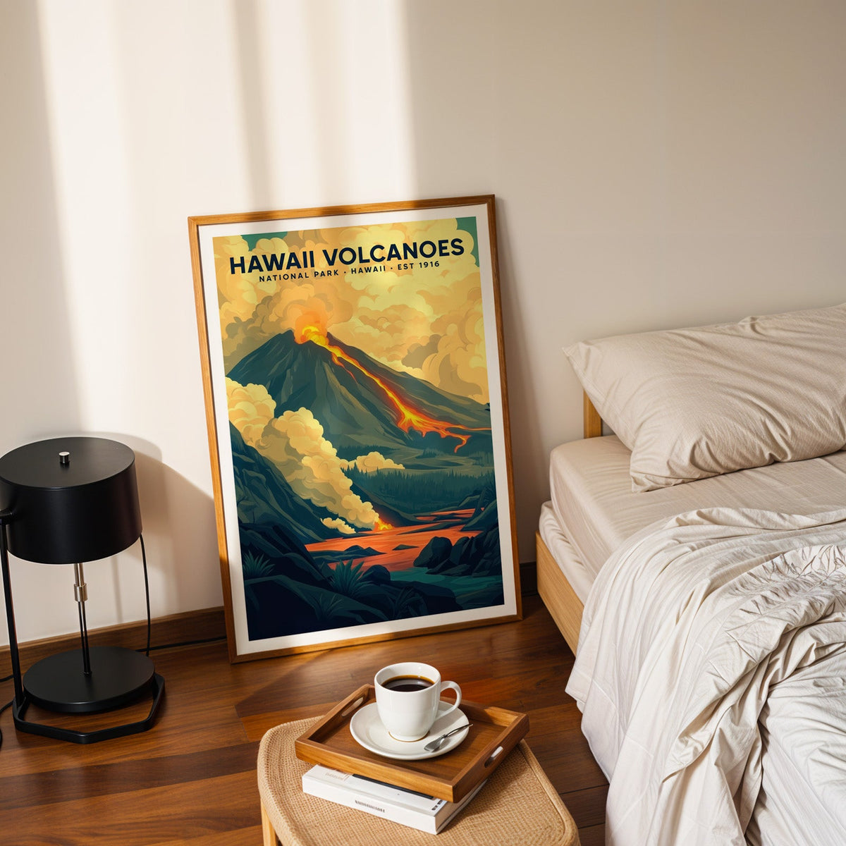 Hawaiʻi Volcanoes print in an oak frame leaning on a bedroom floor beside the bed and a tray