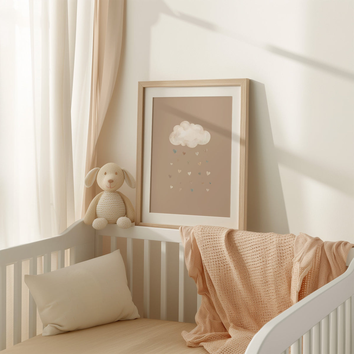 Cloud raining watercolor hearts on latte nursery print shown in an oak frame with a white mat on a crib rail