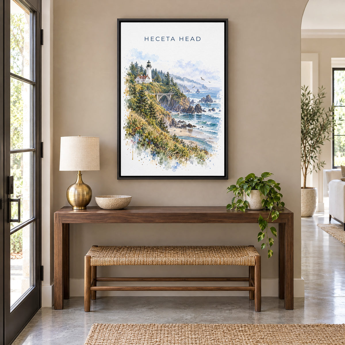 Heceta Head watercolor print as a black floater canvas above a walnut console and woven bench in an entryway