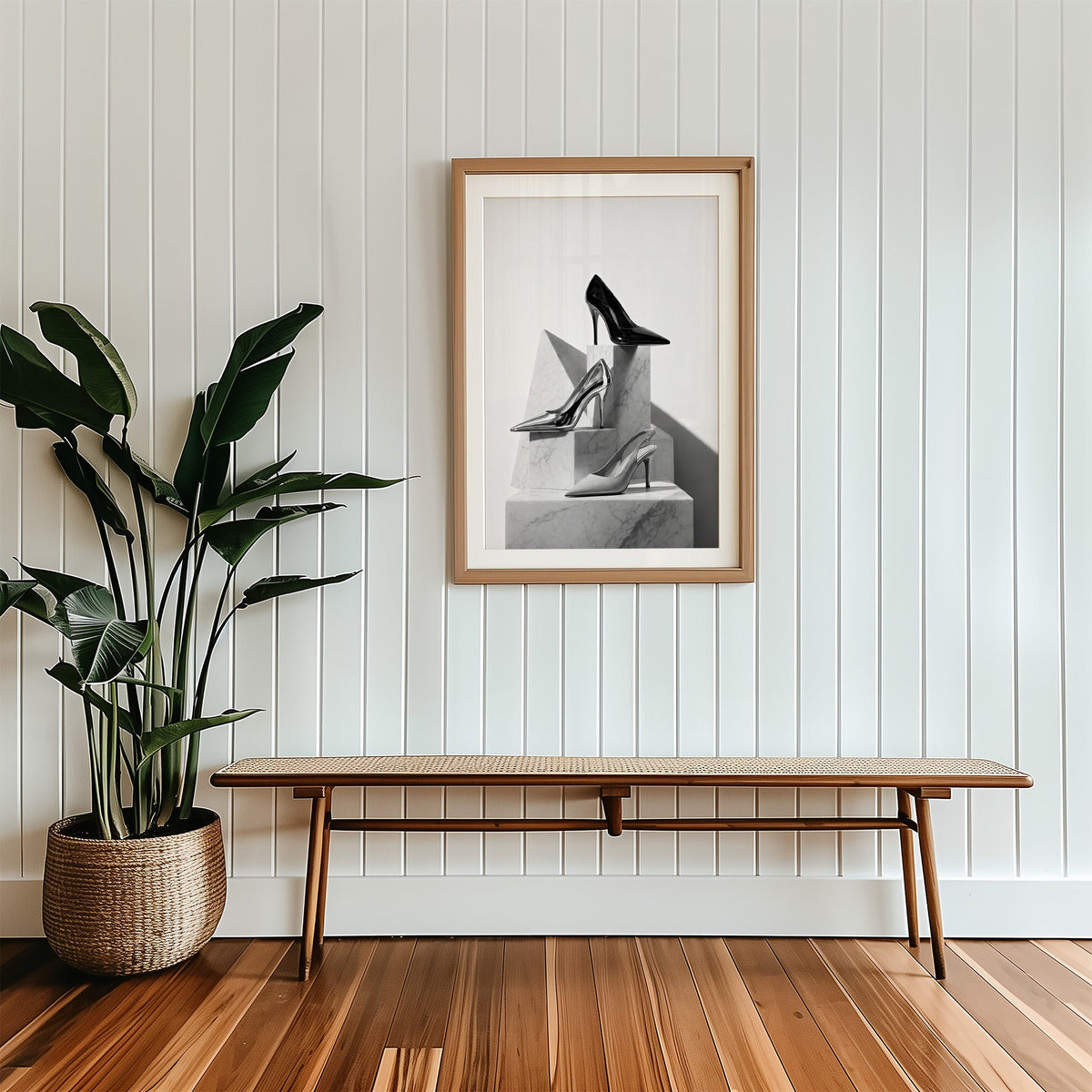 Three pairs of heels on marble pedestals print in a wood frame with a white mat above a cane bench