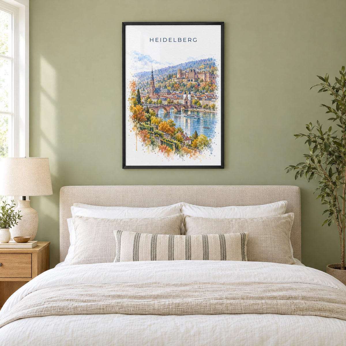 Heidelberg watercolor print in a black frame above an upholstered headboard in a sage green bedroom