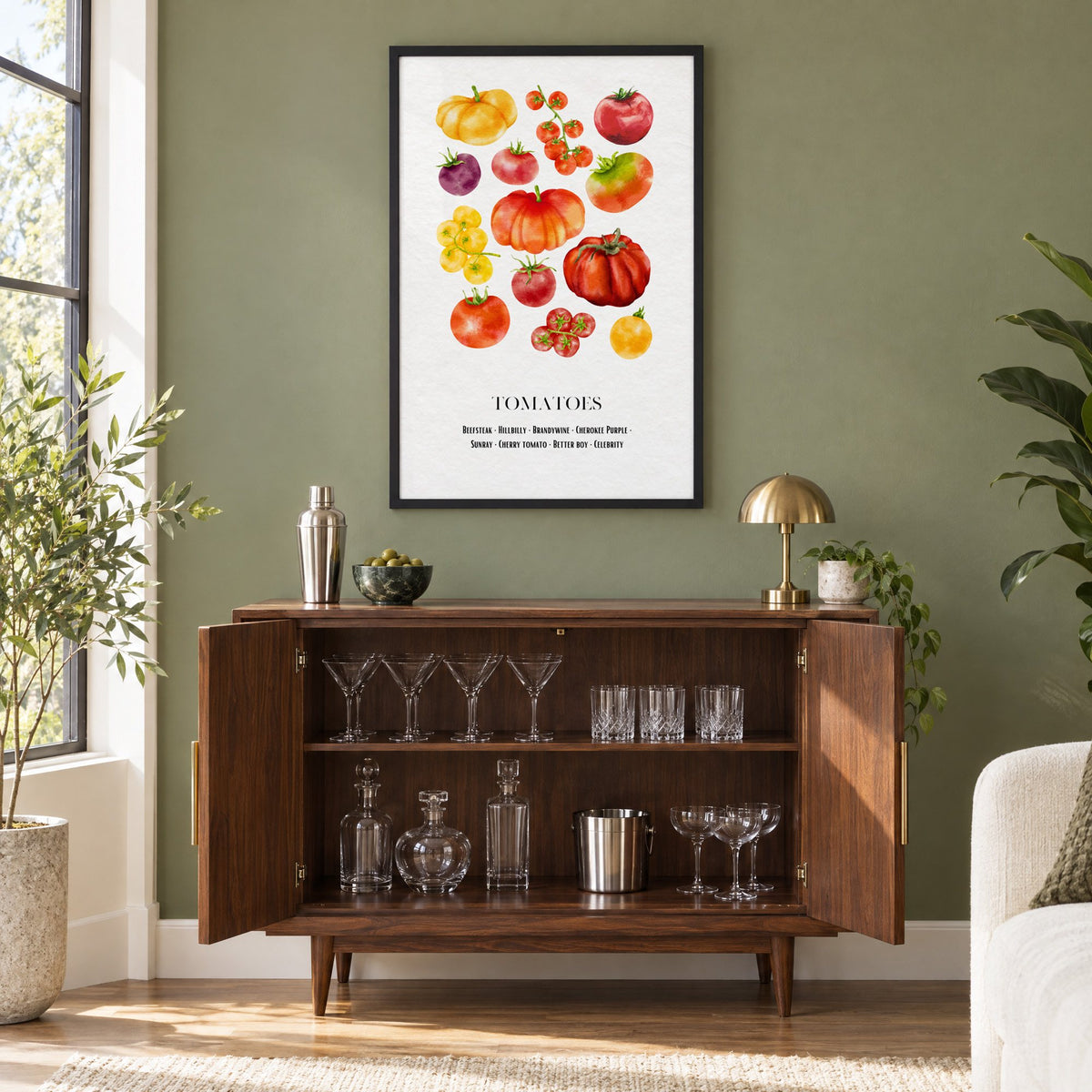 TOMATOES watercolor heirloom varieties chart print in a black frame on an olive green wall above a walnut bar cabinet with glassware
