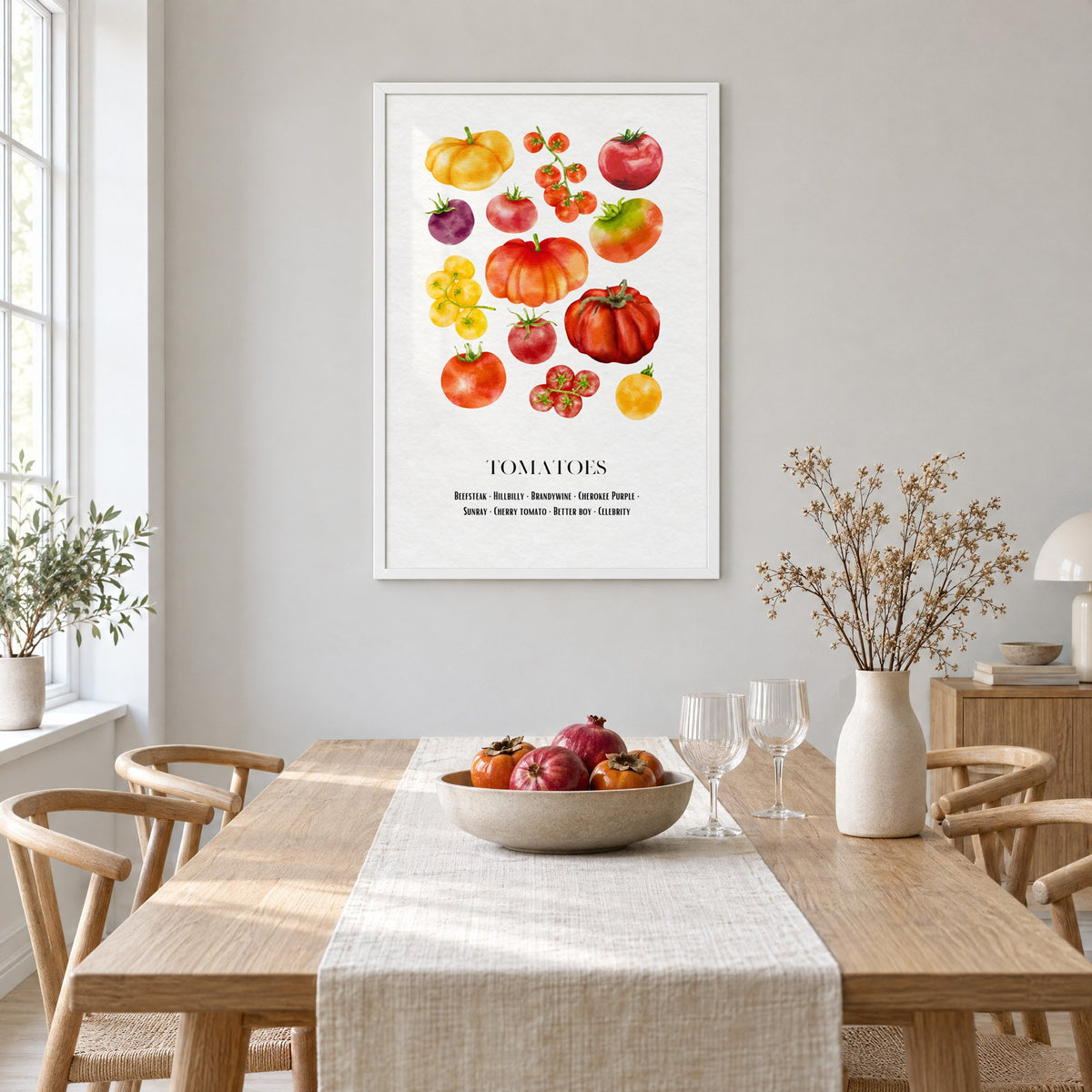 TOMATOES watercolor heirloom varieties chart print in a white frame above a light oak dining table with a linen runner and fruit bowl