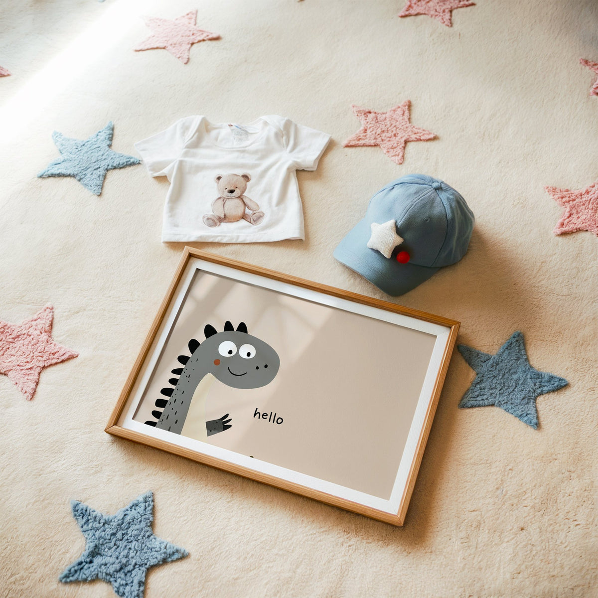 Landscape hello peeking dinosaur nursery print in a matted oak frame on a star rug with a baby tee