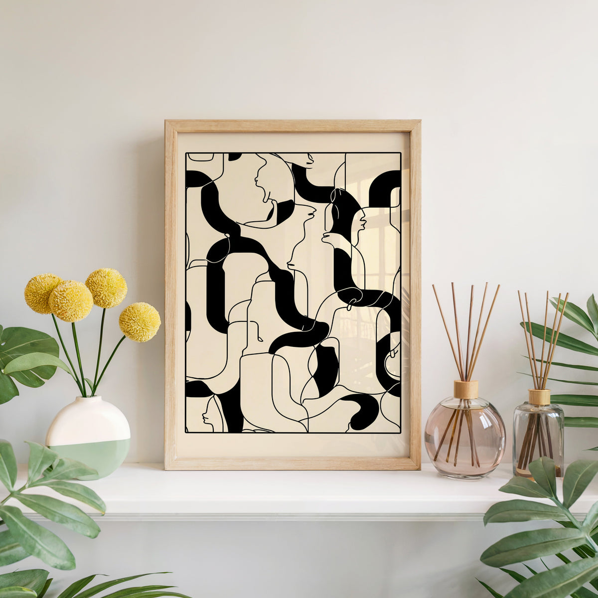 Hidden faces line art maze minimalist print in a light oak frame leaning on a white mantel with yellow flowers