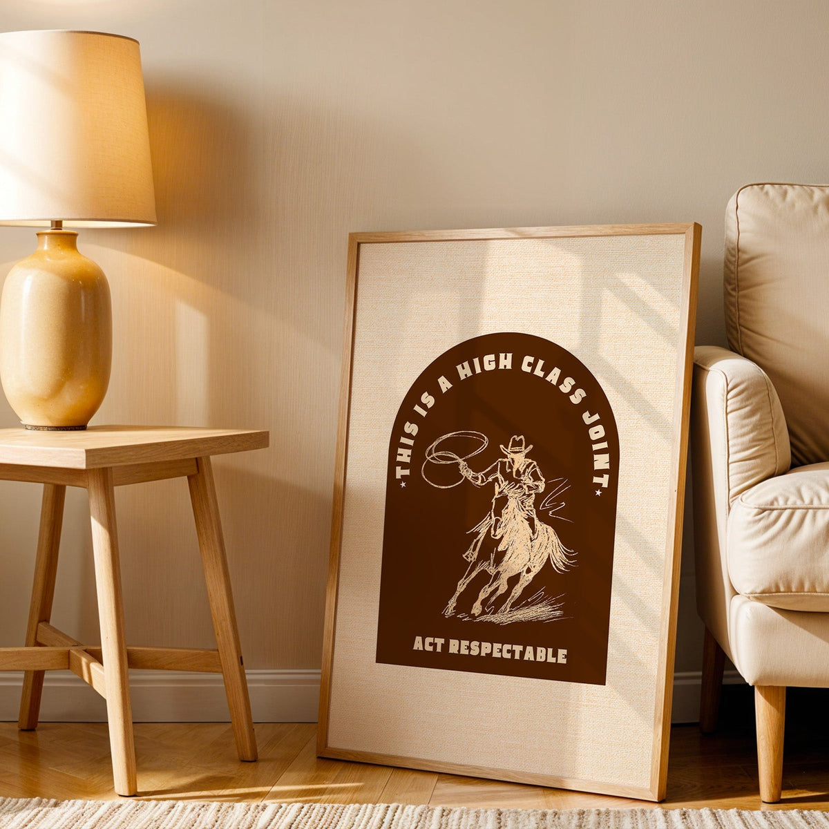 High Class Joint arch brown print in an oak frame beside an amber ceramic lamp