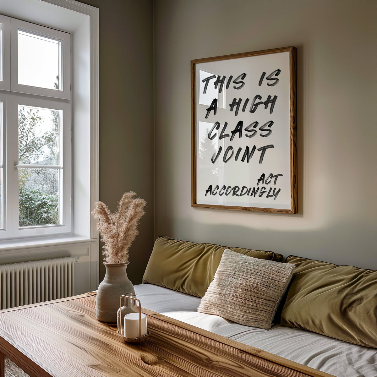 This is a high class joint brush quote print in a walnut frame above an olive daybed by a window