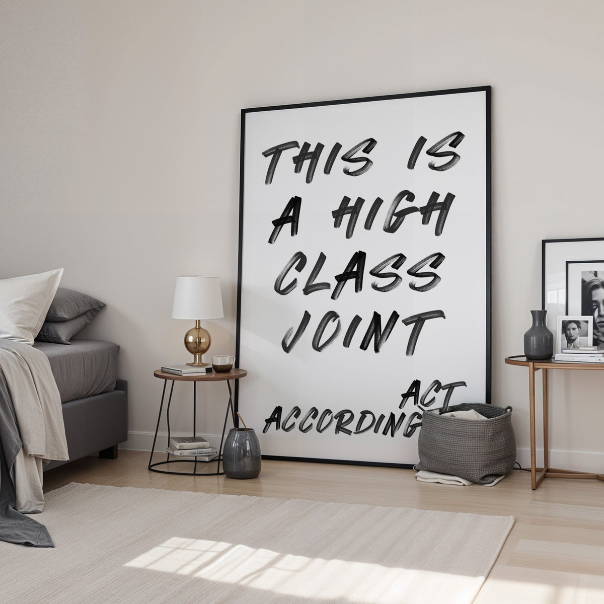 This is a high class joint brush quote print in a black frame leaning in a bedroom beside a gold lamp