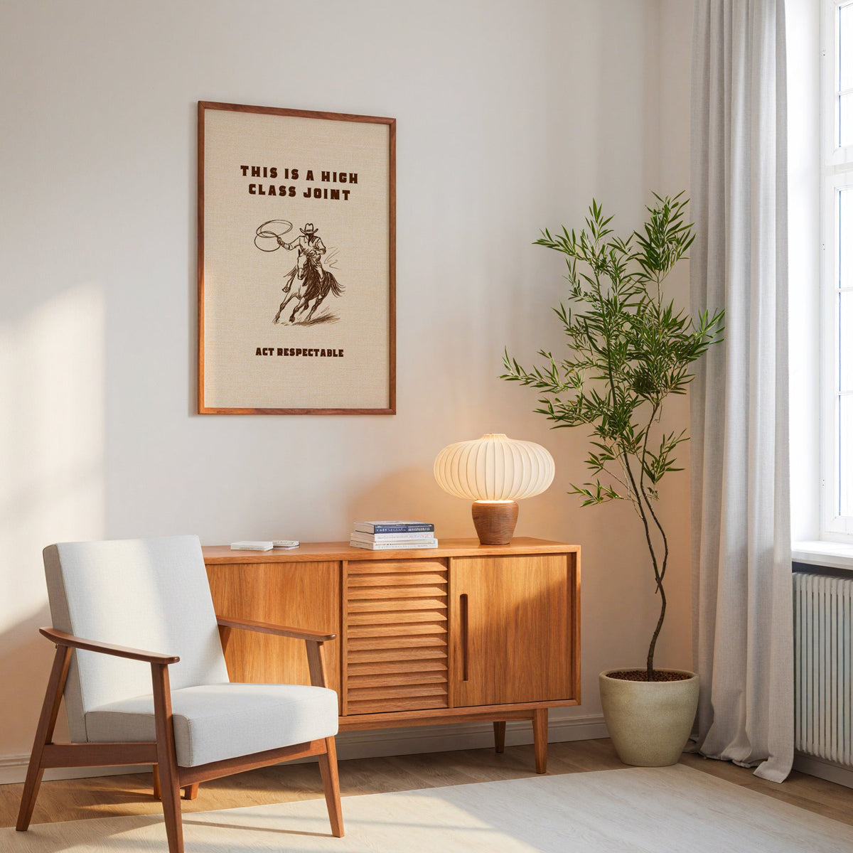High Class Joint cowgirl cream print in an oak frame above a mid-century sideboard