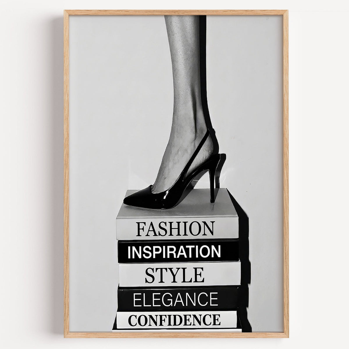 Black slingback heel on stack of word books print in a light oak frame on a plain white wall
