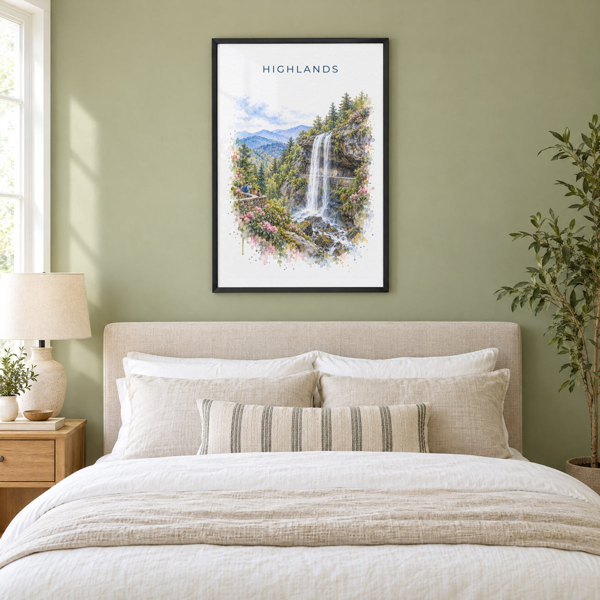 Highlands, North Carolina watercolor print in a black frame above an upholstered headboard in a sage green bedroom