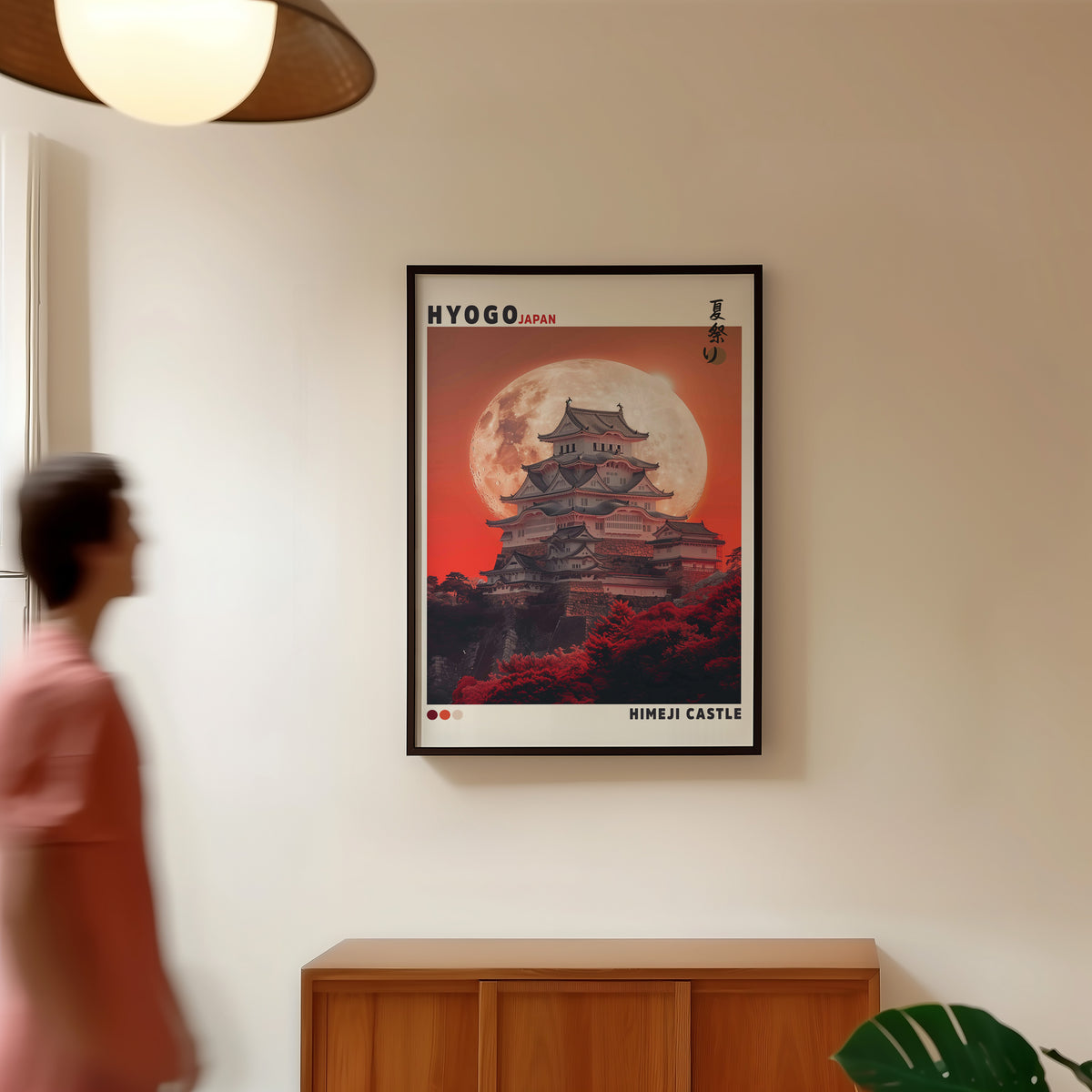 Himeji Castle red moon print in a black frame in a hallway under a rattan pendant