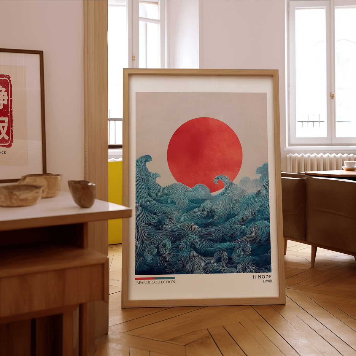 Hinode red sun over waves print in an oak frame on the parquet floor of a sunlit living room