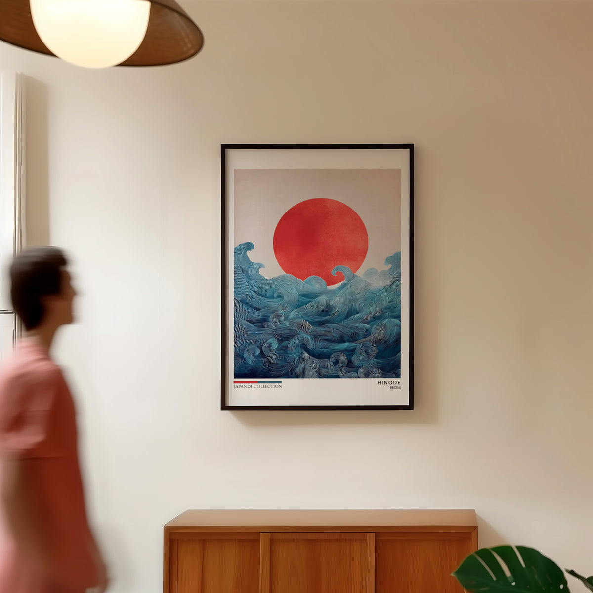 Hinode red sun over waves print in a black frame in a hallway under a rattan pendant