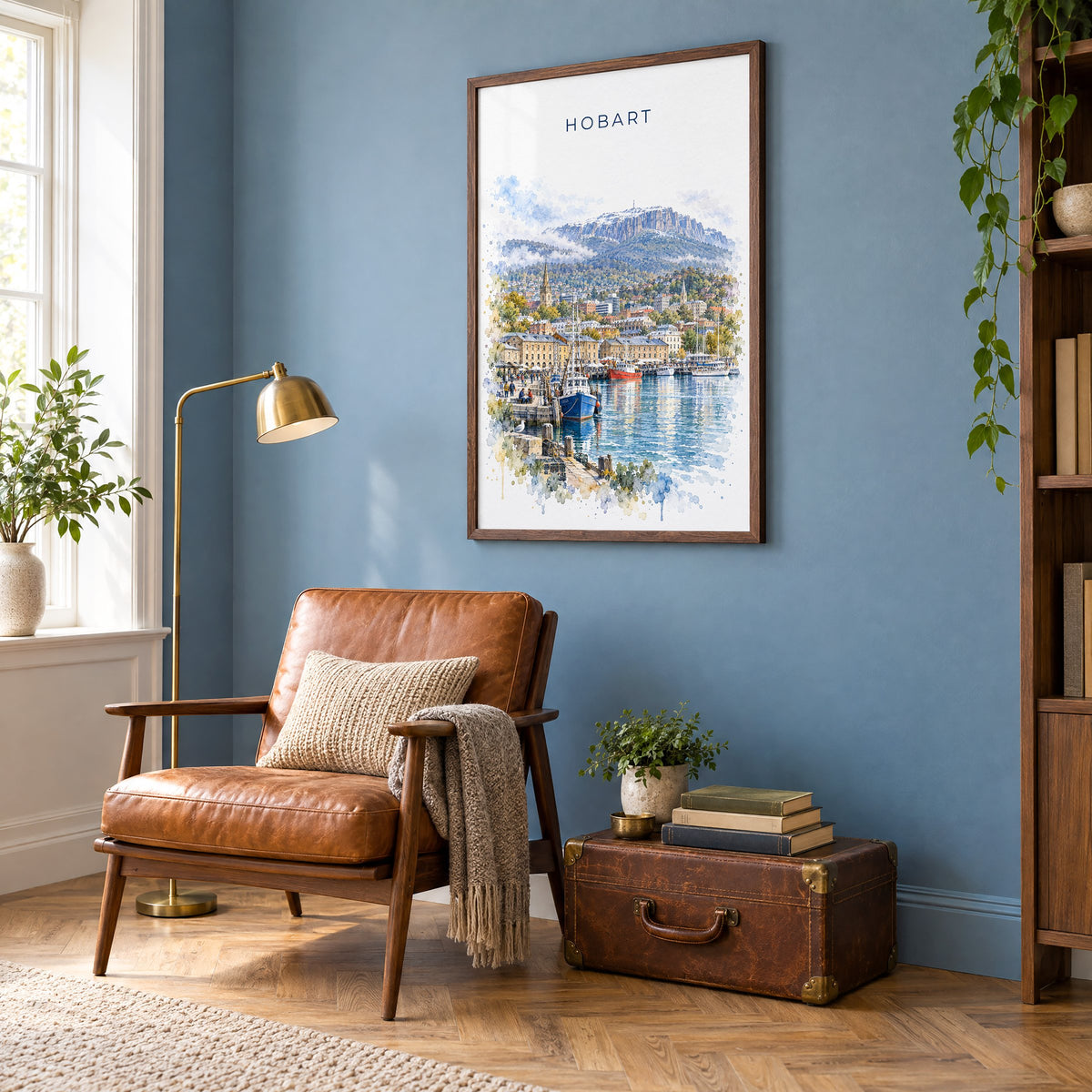 Hobart watercolor print in a walnut frame on a blue wall above a leather armchair in a reading nook