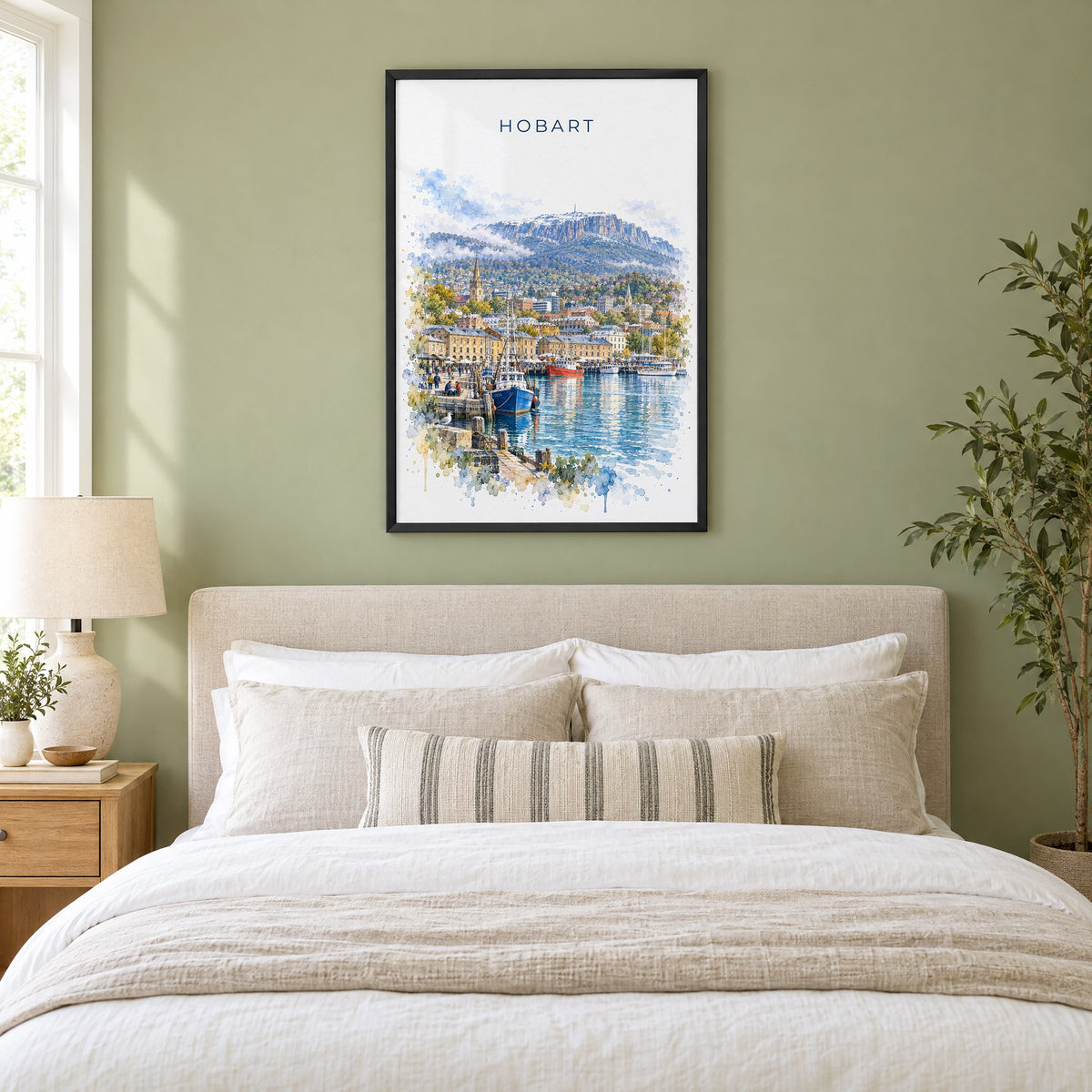 Hobart watercolor print in a black frame above an upholstered headboard in a sage green bedroom