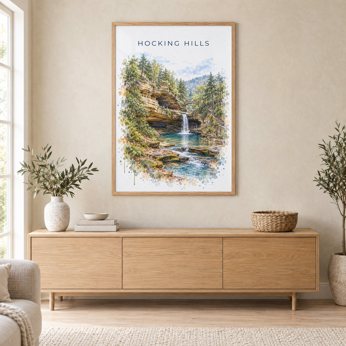 Hocking Hills watercolor print in an oak frame above a light wood sideboard in a Scandinavian living room
