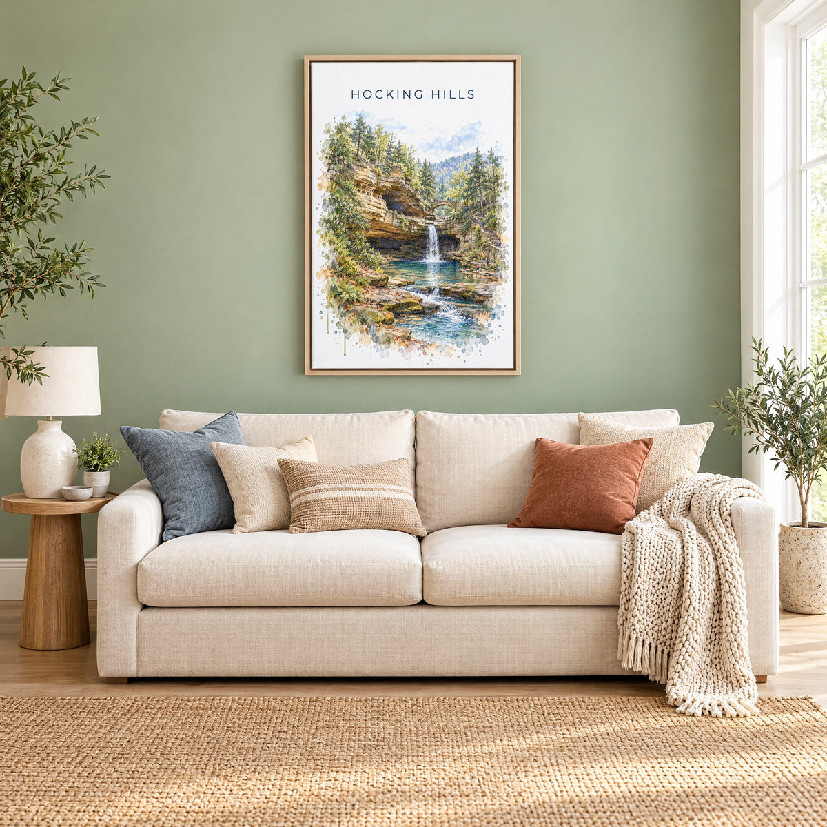 Hocking Hills watercolor print as a natural floater canvas above a cream linen sofa on a sage green wall