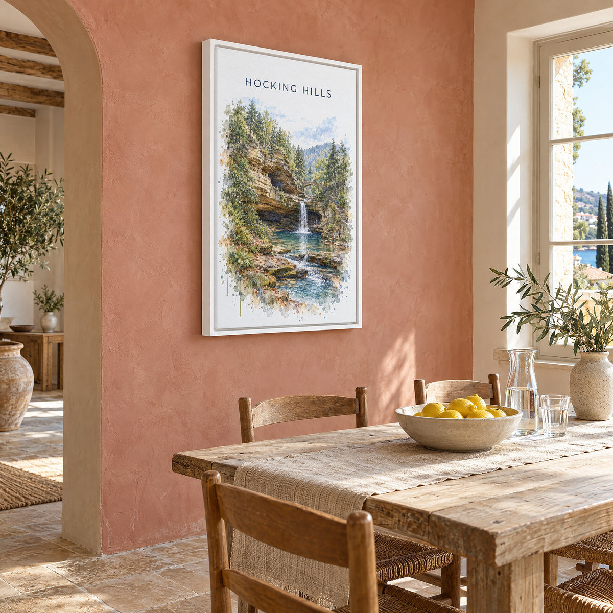 Hocking Hills watercolor print as a white floater canvas on a terracotta wall above a rustic dining table