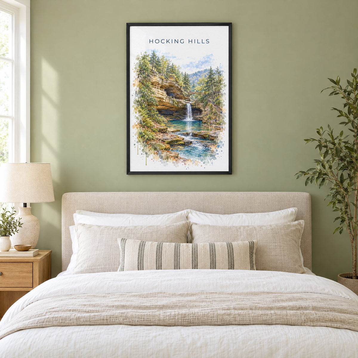 Hocking Hills watercolor print in a black frame above an upholstered headboard in a sage green bedroom
