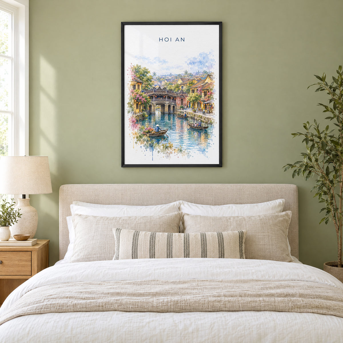 Hoi An watercolor print in a black frame above an upholstered headboard in a sage green bedroom