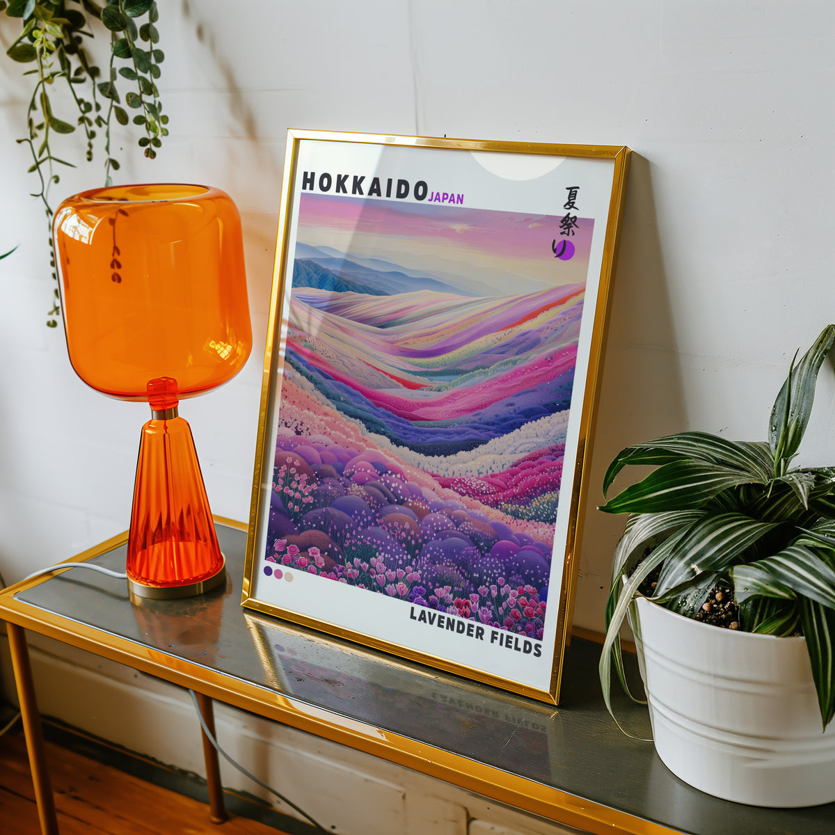 Hokkaido lavender fields print shown in a gold frame on a console beside an orange glass lamp