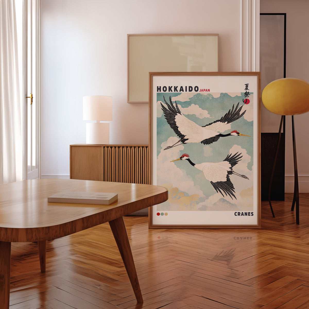 Hokkaido red-crowned cranes in flight print in a walnut frame leaning in a mid-century living room