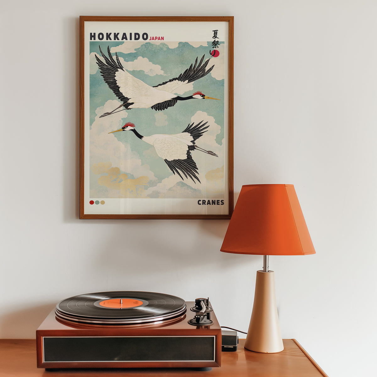 Hokkaido red-crowned cranes in flight print in a walnut frame above a sideboard with a record player