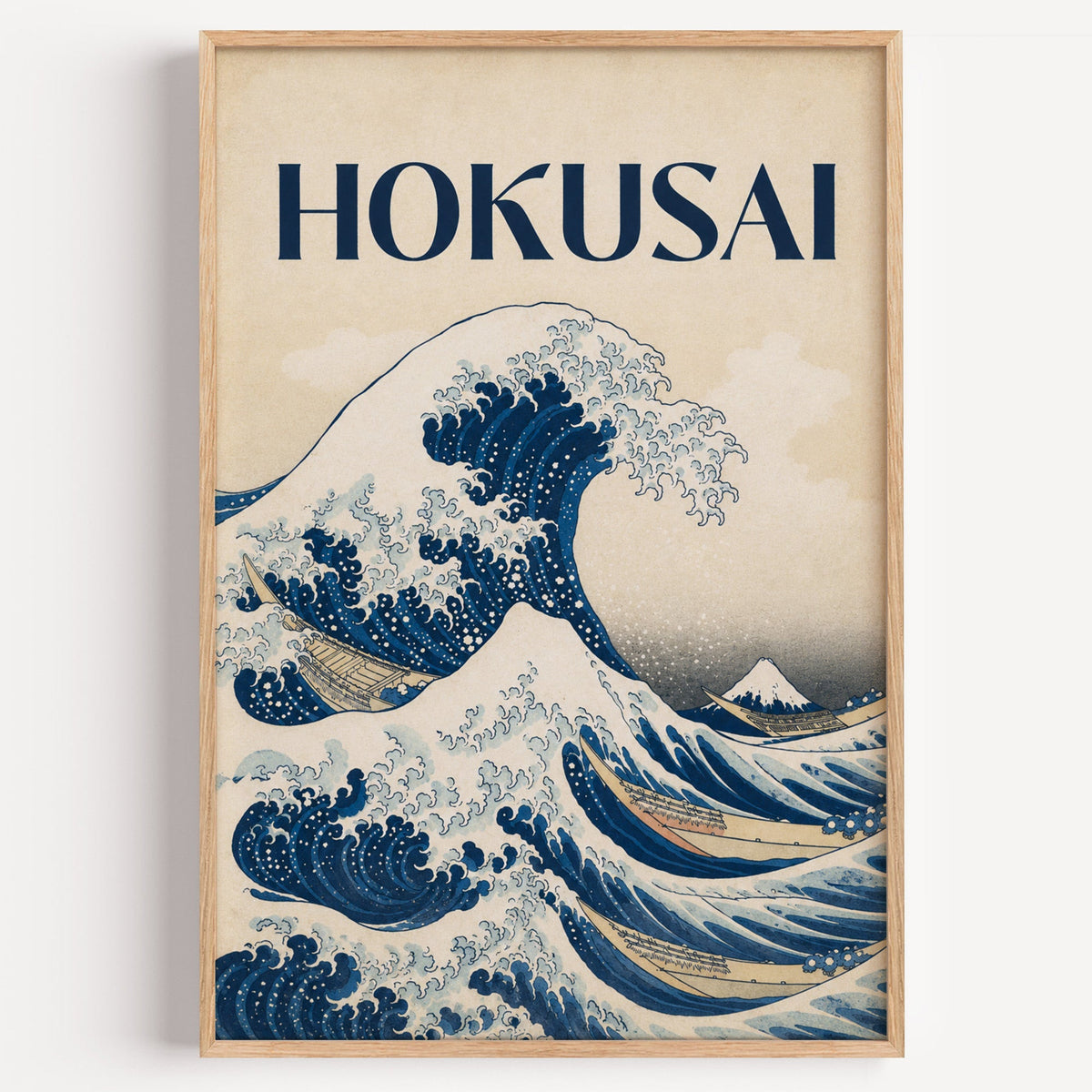 Great Wave with HOKUSAI title print in a light oak frame on a plain white wall