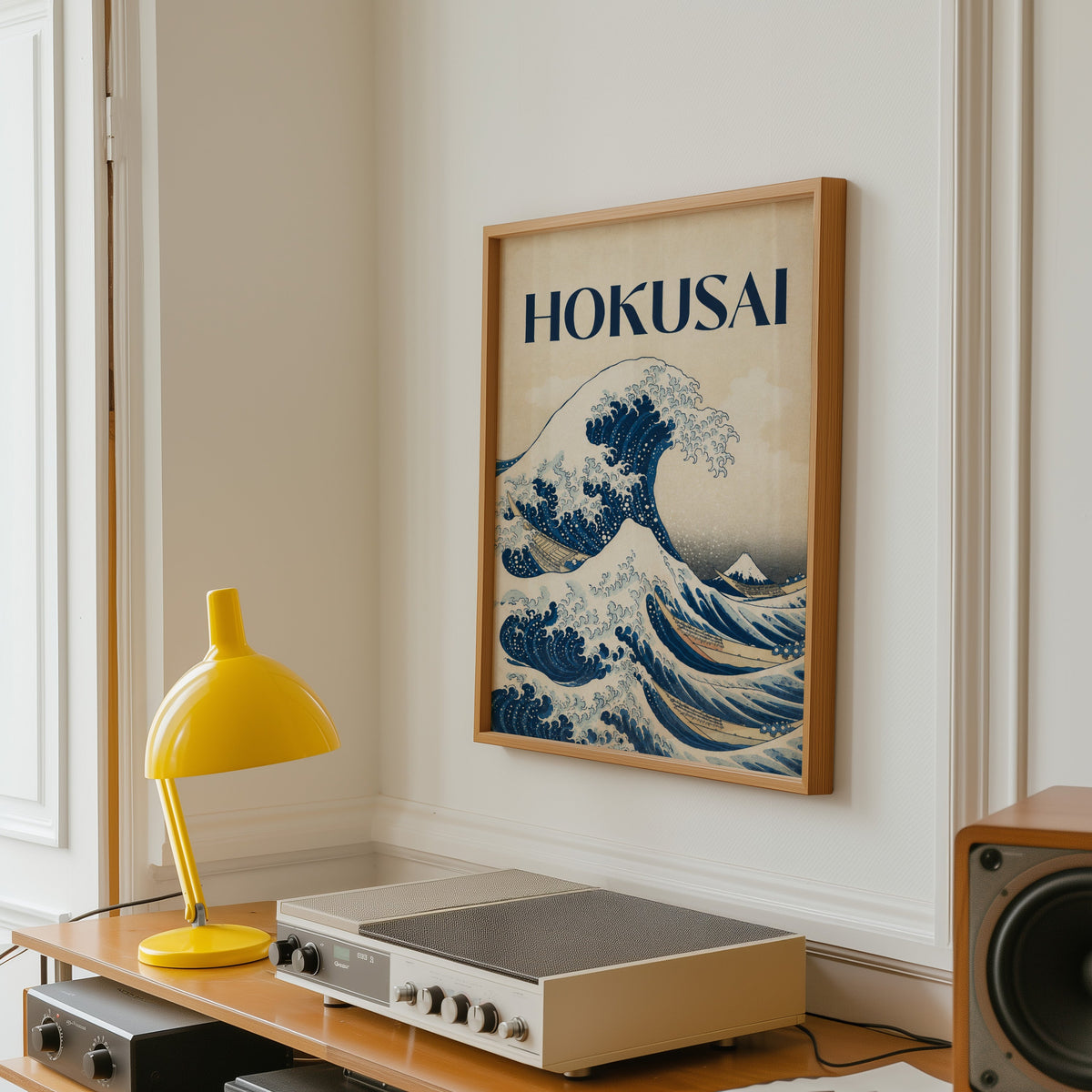 Great Wave with HOKUSAI title print in an oak frame above a vintage hi-fi shelf with a yellow desk lamp