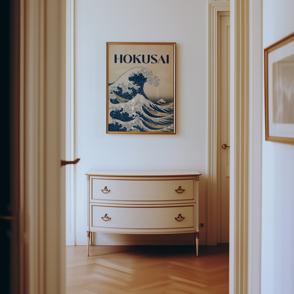 Great Wave with HOKUSAI title print shown in a gold frame in a hallway above a cream dresser