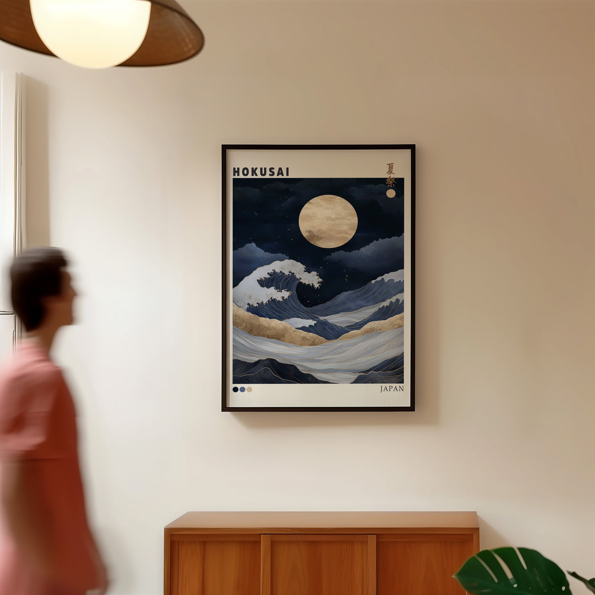 Hokusai night wave gold moon print in a black frame in a hallway under a rattan pendant