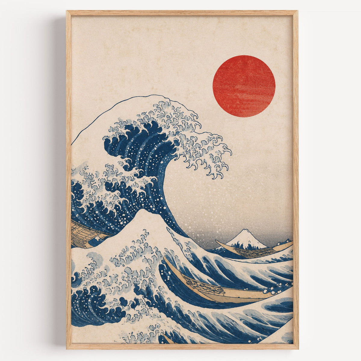 Great Wave with red sun print in a light oak frame on a plain white wall