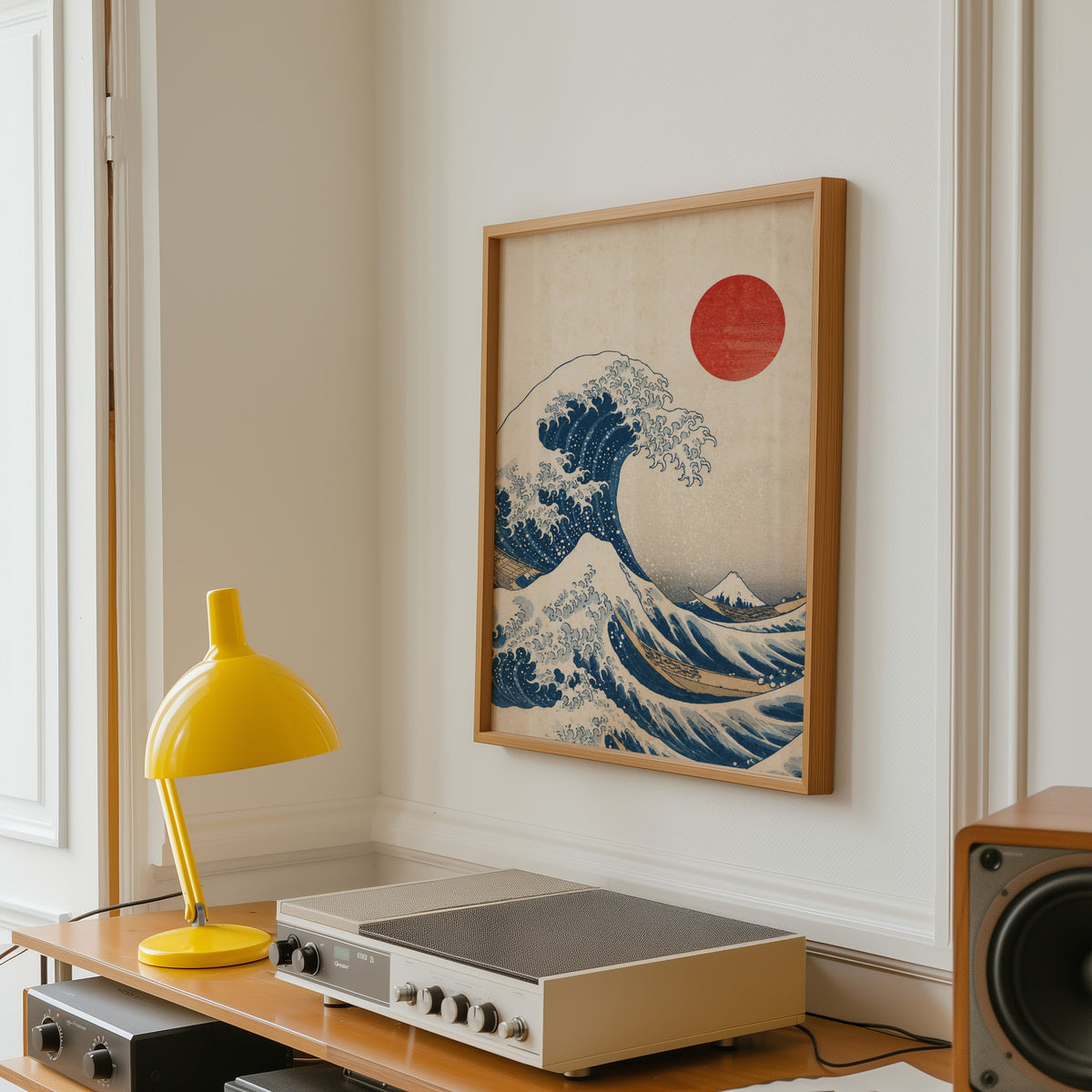 Great Wave with red sun print in an oak frame above a vintage hi-fi shelf with a yellow desk lamp