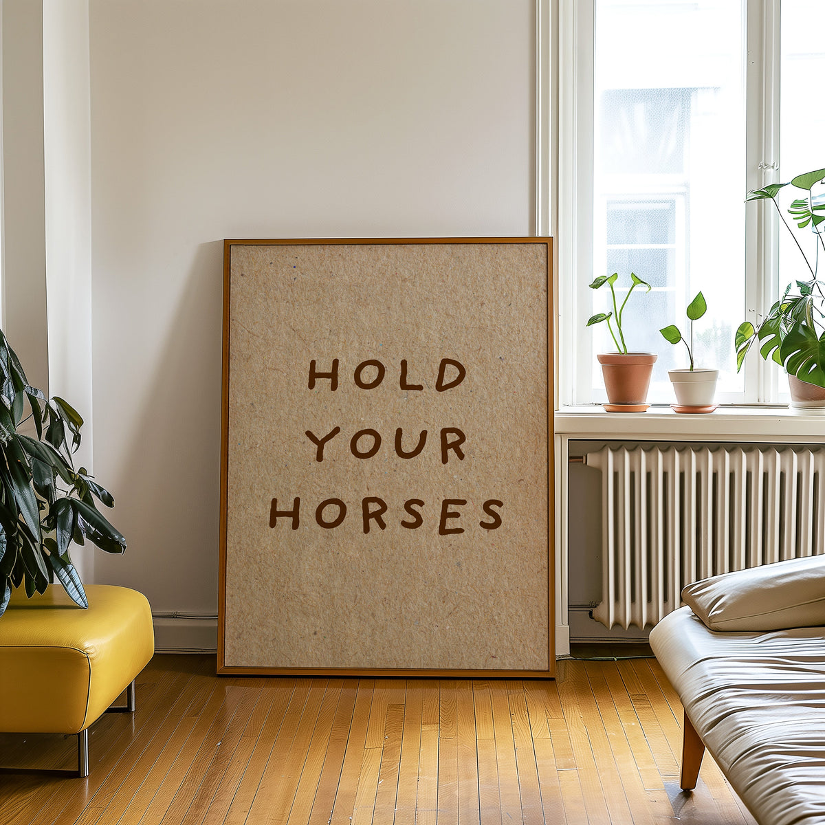 Hold Your Horses kraft print in an oak frame on a parquet floor beside a yellow bench