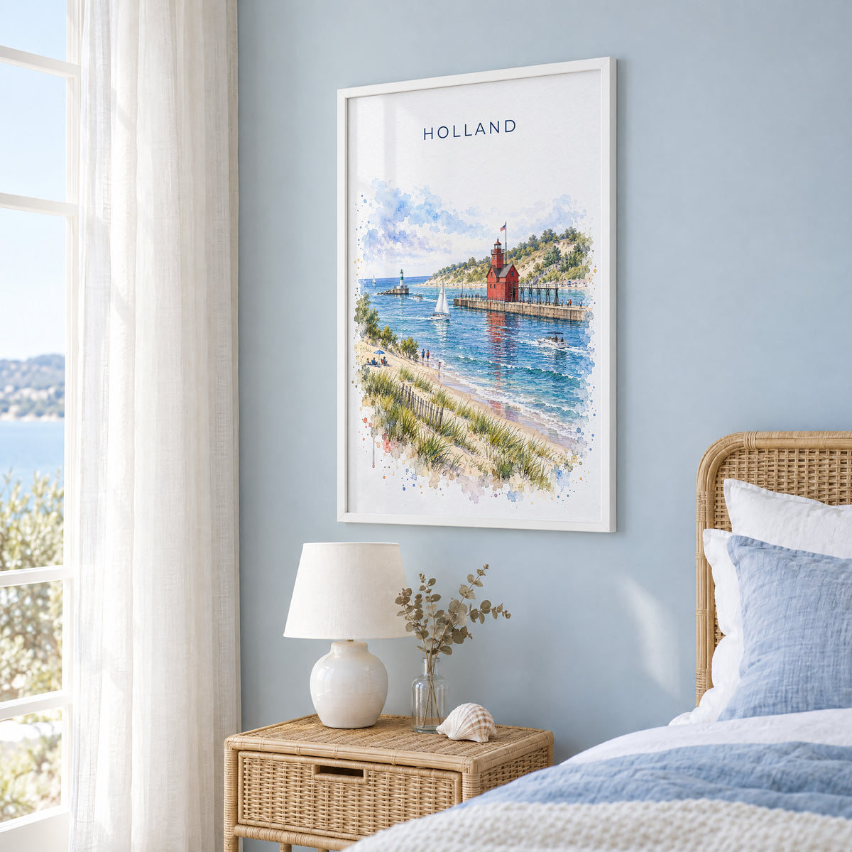 Holland, Michigan watercolor print in a white frame on a pale blue wall beside a rattan bed in a coastal bedroom