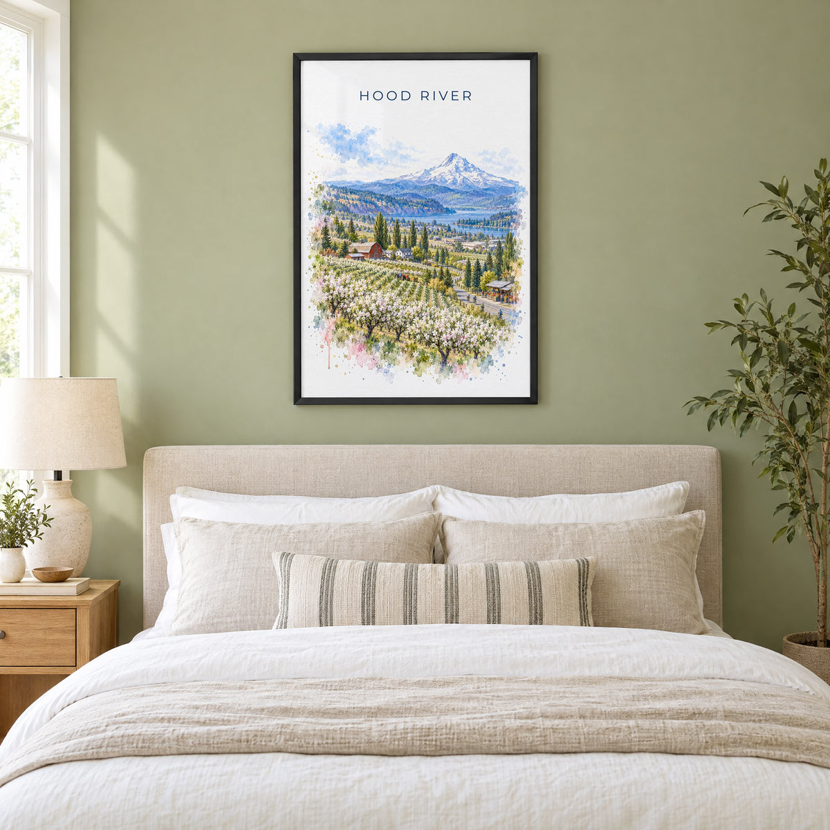 Hood River watercolor print in a black frame above an upholstered headboard in a sage green bedroom