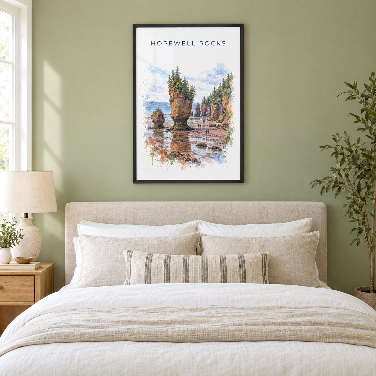 Hopewell Rocks watercolor print in a black frame above an upholstered headboard in a sage green bedroom