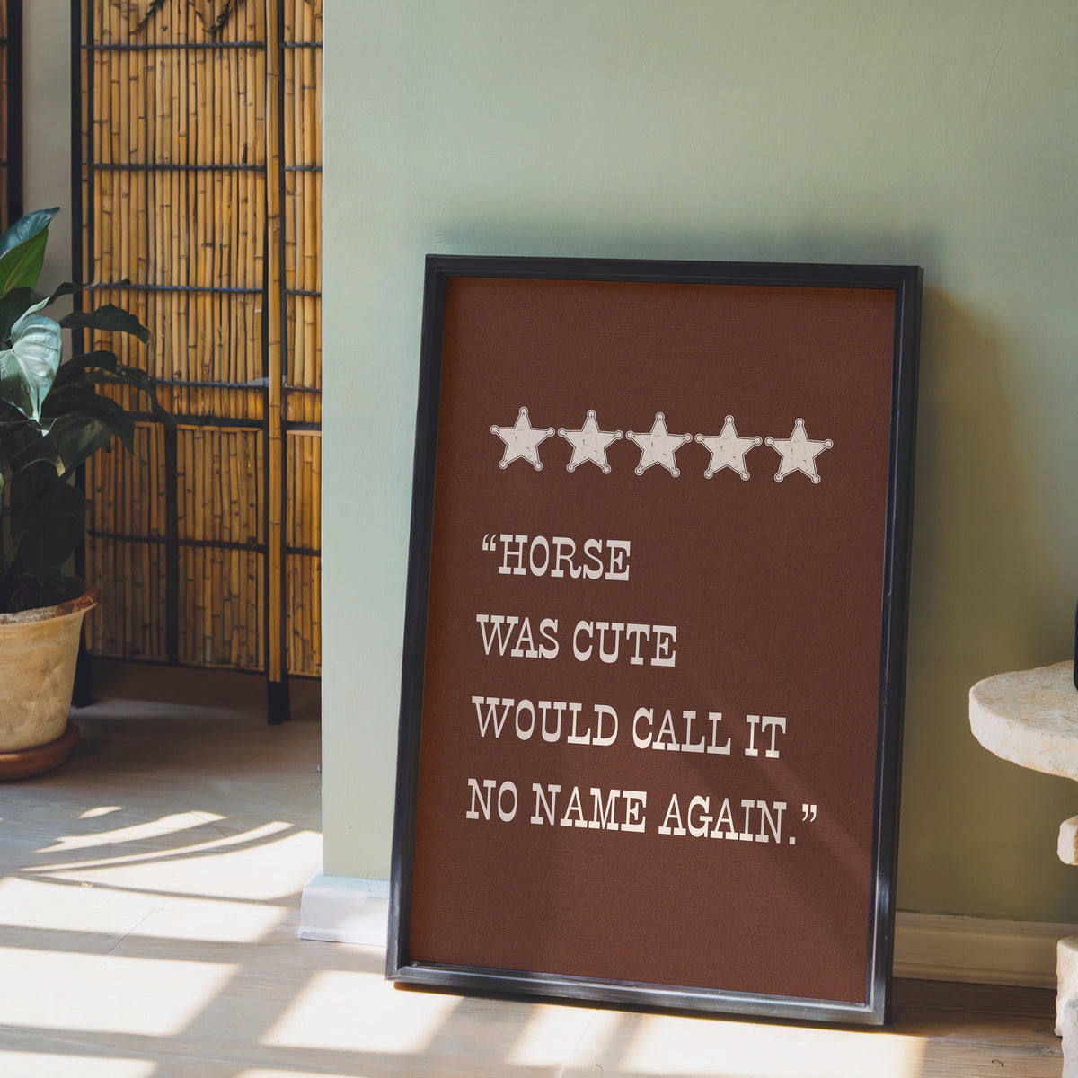 Horse Was Cute brown print in a black frame leaning against a sage green wall