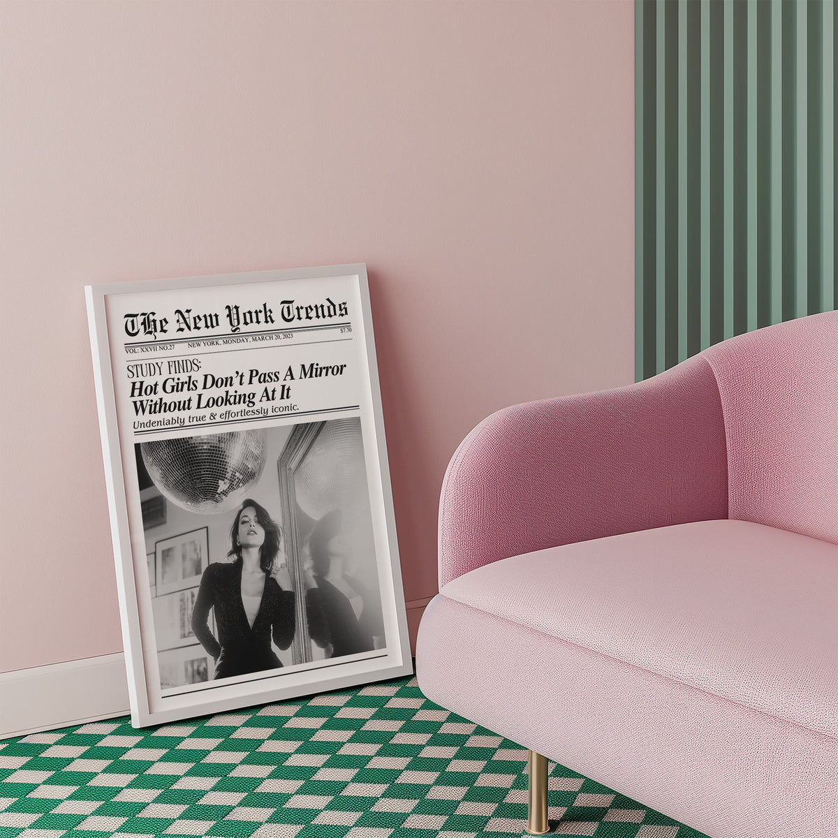 Woman by mirror with disco ball mock newspaper print in a white frame beside a pink armchair on a checkered floor