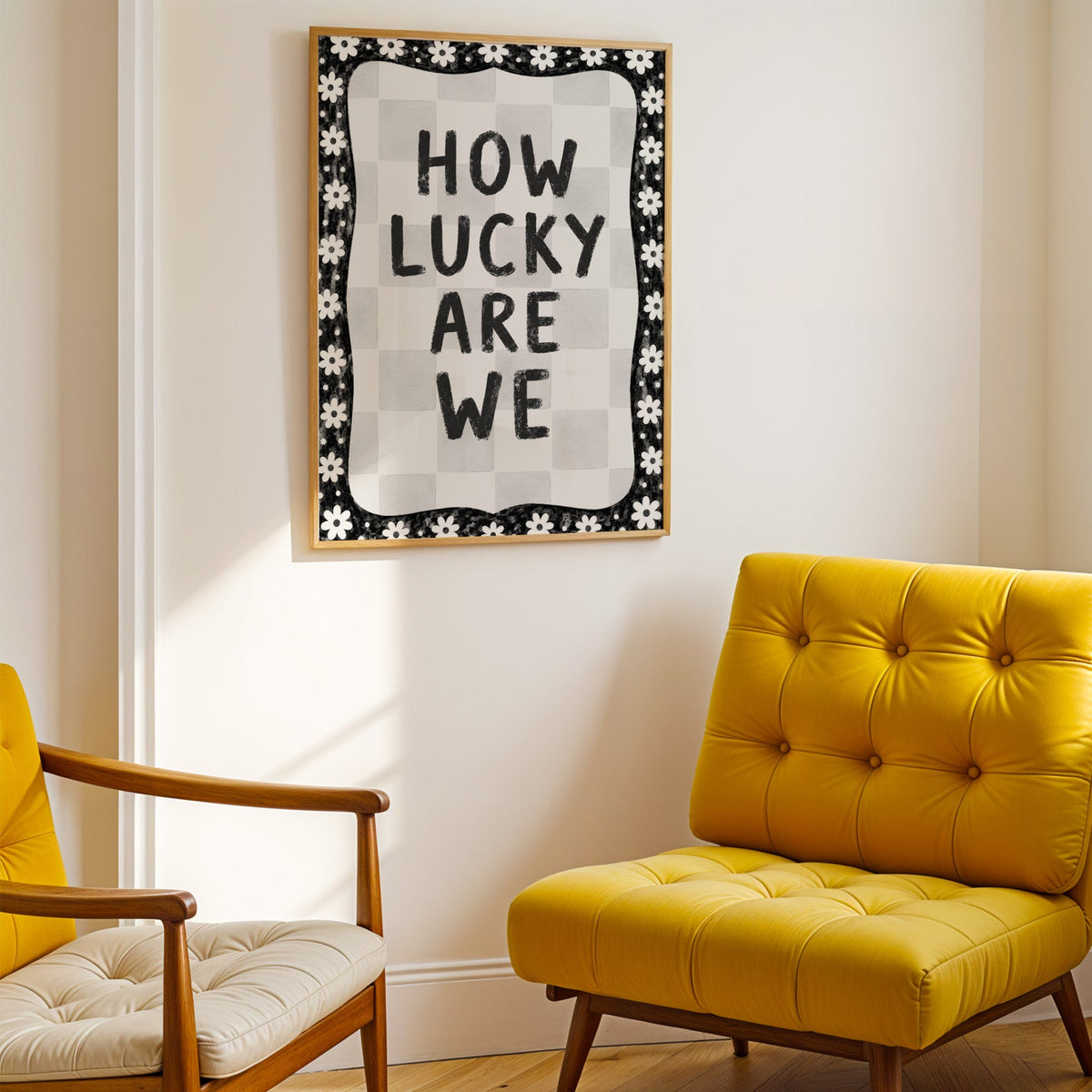 How lucky are we quote with white daisy border print shown in a gold frame above a mustard yellow tufted armchair